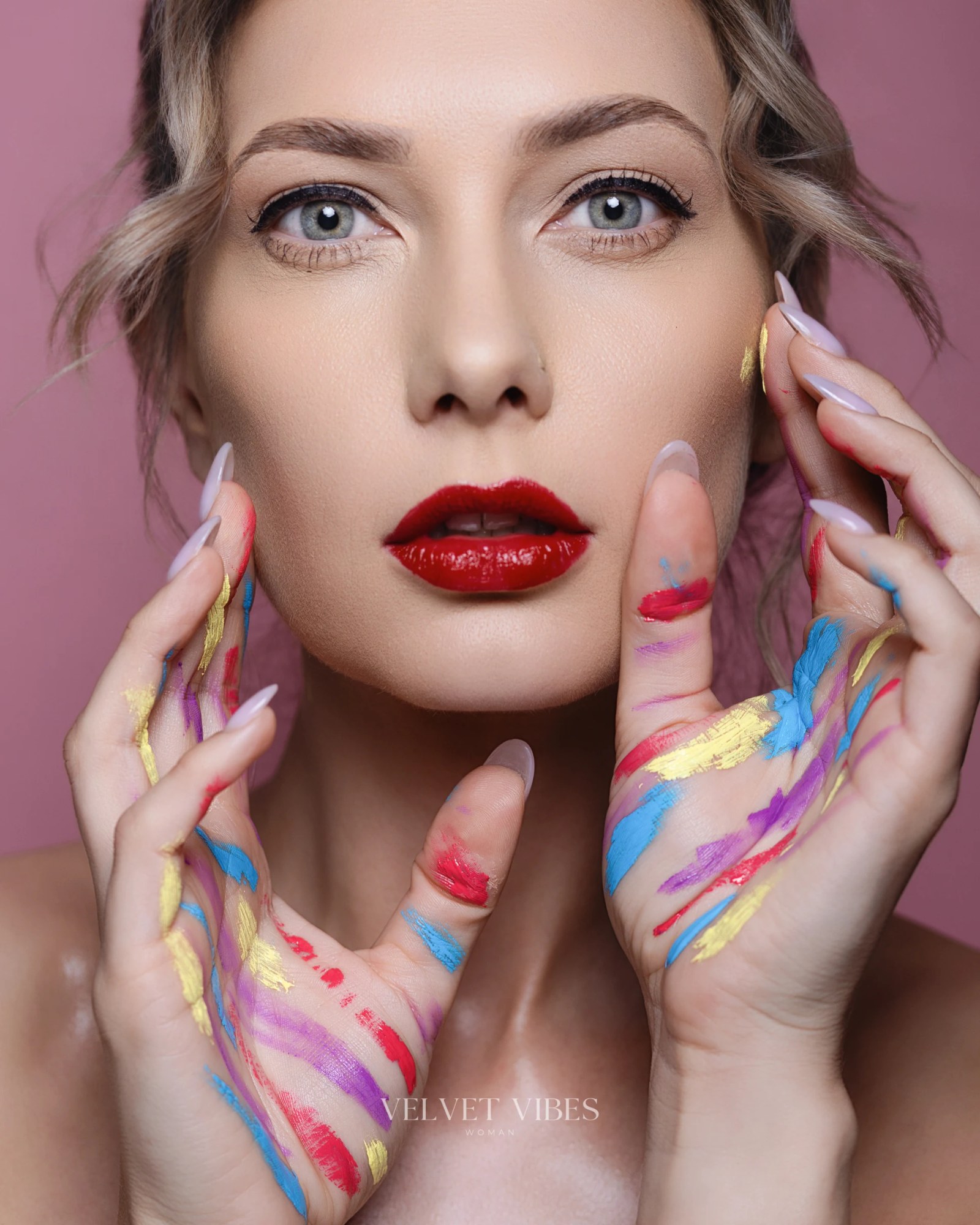 Olesia Prodan framed by color-painted hands in a conceptual beauty portrait