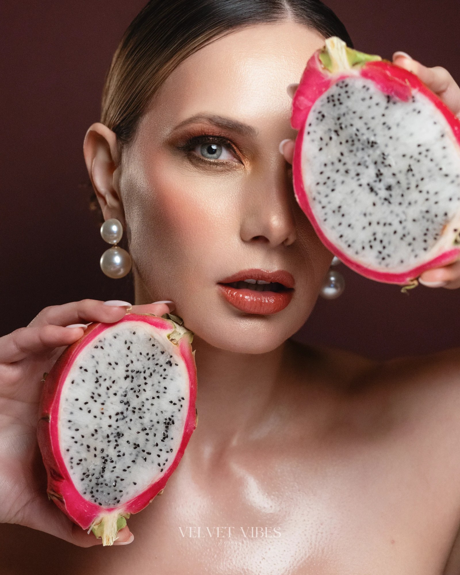 Glossy beauty portrait of Olesia Prodan holding cut dragon fruit