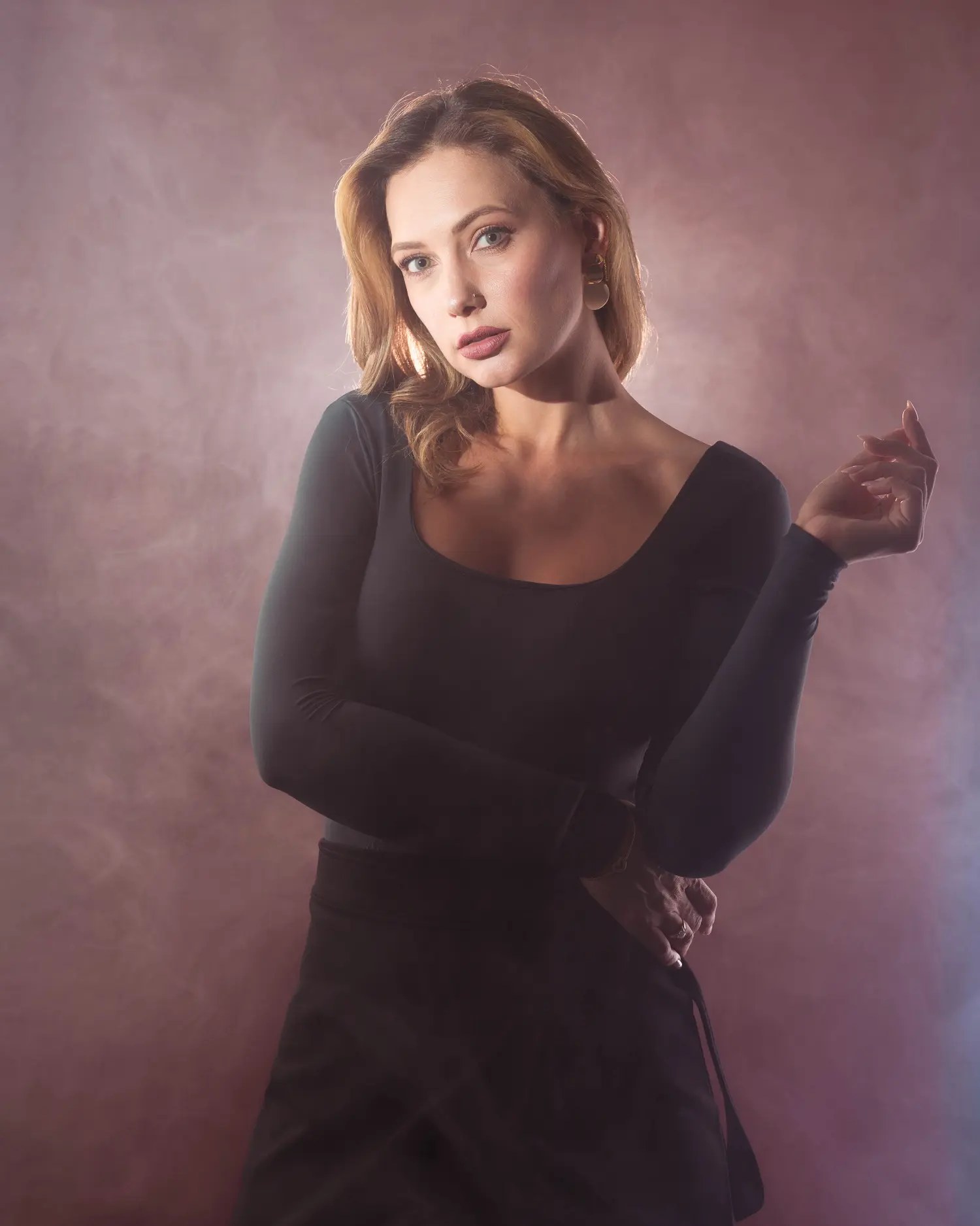 Olesia Prodan in a black dress surrounded by soft theatrical haze