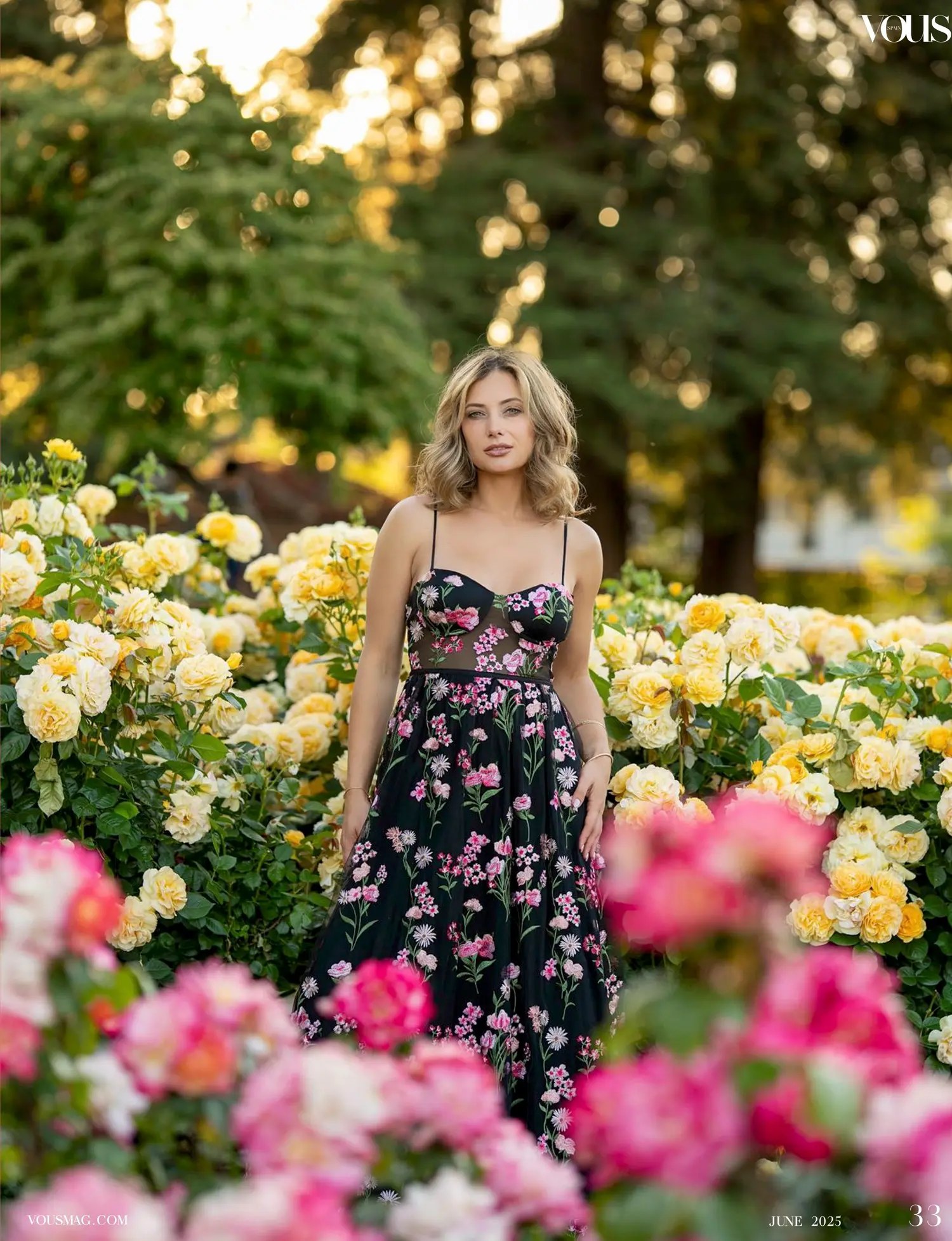 Olesia Prodan wearing a floral dress among yellow roses at golden hour